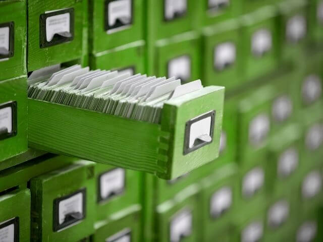 Row of green file cabinets, with a focus on one that is open.