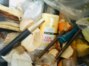 Close-up of a bunch of trash. Including banana peels, orange peels and makeup.