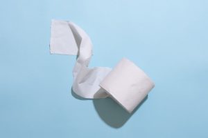 Roll of toilet paper laid on a blue background.