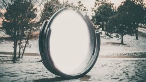 A portal with a grey rim, out in a sparse snowy forest.