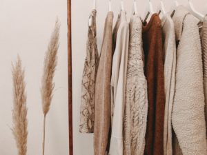 A few brown and white shirts on a clothing rack.