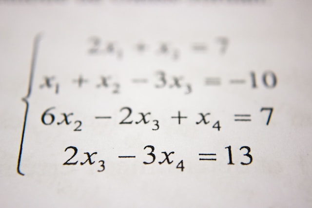Close up on some paper with solve for x equations on it.