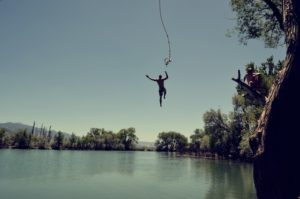 Landscape of a smooth lake with a person jumping in.