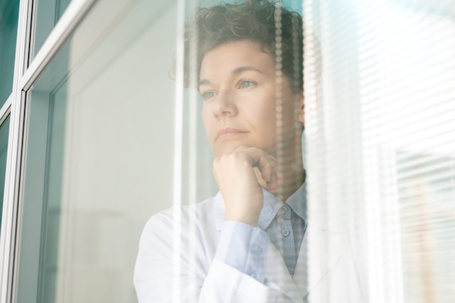 Close-up on a person staring through a clear window.