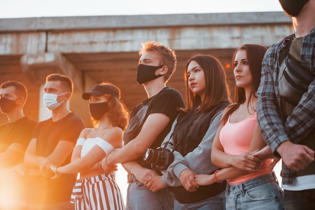 Seven young adults holding hands on a city street in protest.