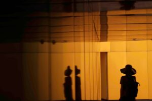 A wide shot of a person's silhouette standing by reflective walls.