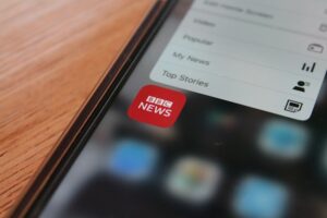 A close-up on a phone hovering over a news app.
