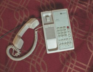 A corded home telephone laid out on a red sheet.