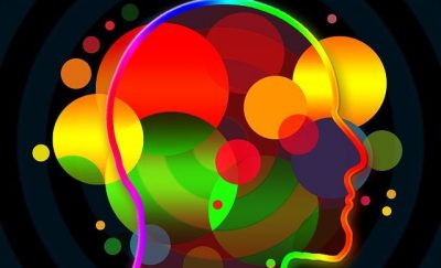 Multi-colour outline of a head, with a few big and colourful dots in it.