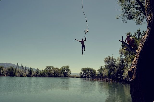 Landscape of a smooth lake with a person jumping in.