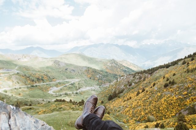 Legs resting near the camera in front of an expansive landscape.