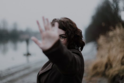 priscilla-du-preez-GFLVQDTPKcM-unsplash Person stretching their hand out towards the camera, covering their face from the lens.