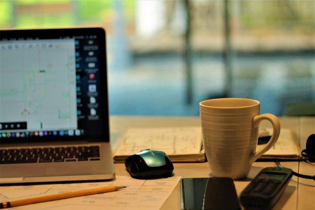A couple of items sitting next to a computer on a desk.